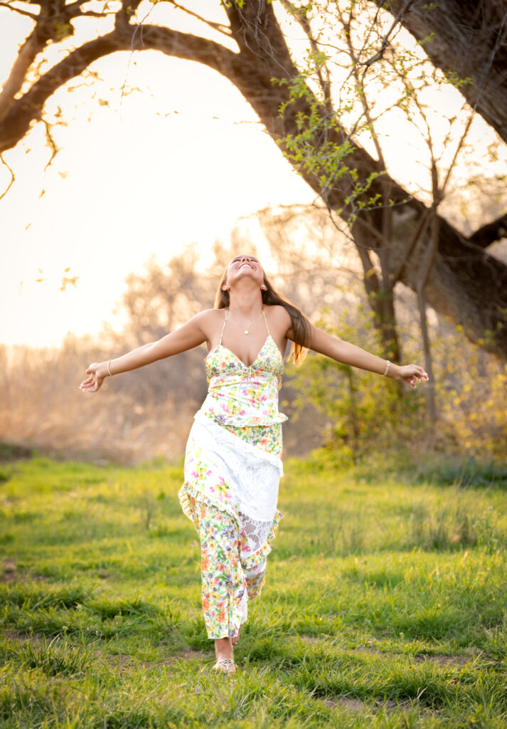 high school senior in a grassy field looking at the sky