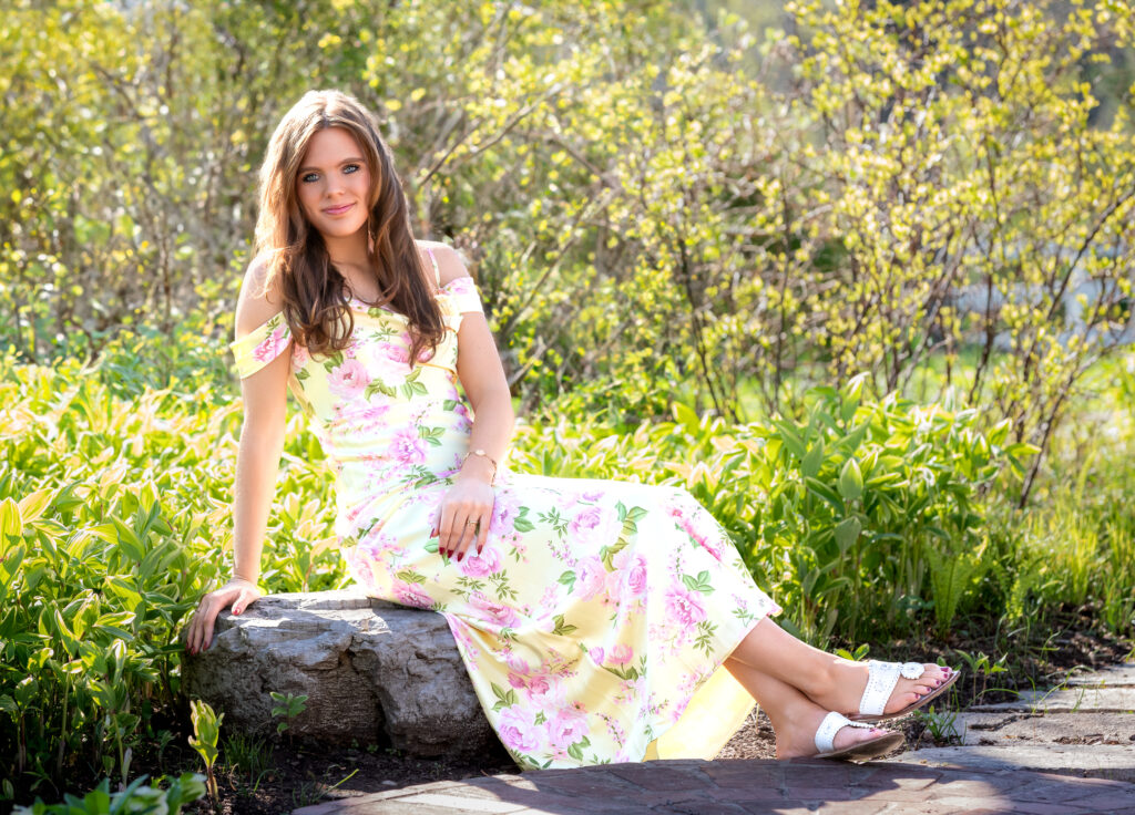 senior portrait with girl sitting on a rock