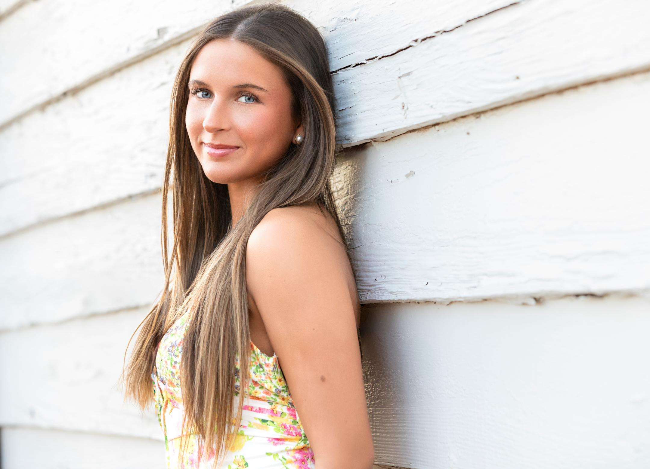 high school senior leaning against a barn