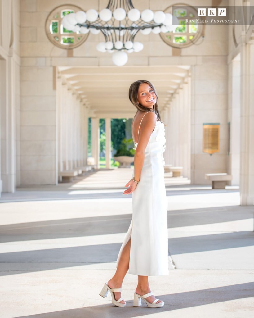 High school senior at the Muny chandelier in a long white dress