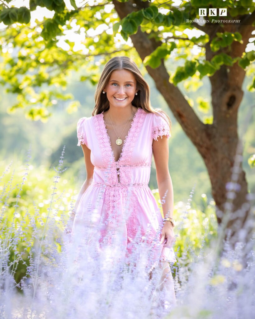 High school senior in spring in a lavender field with brown hair blue eyes pink dress