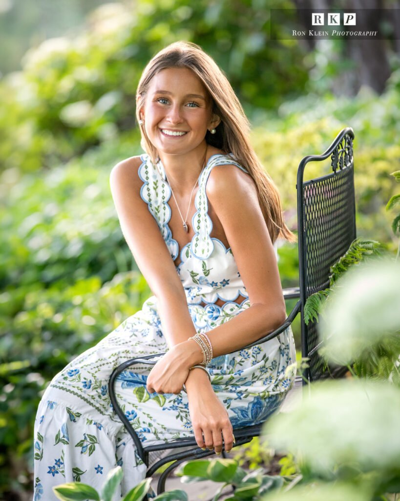 High school senior on park bench in blue floral dress