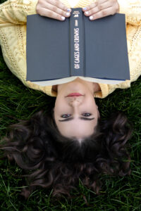 High School Senior Spring Session. Reading a book laying in the grass upside down.