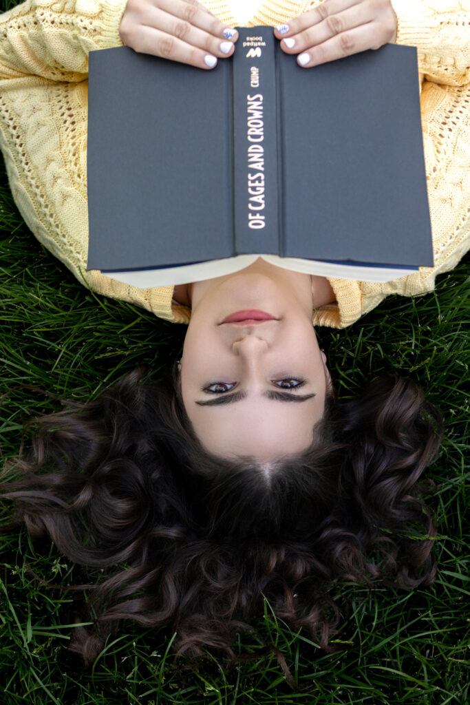 High School Senior Spring Session. Reading a book laying in the grass upside down.