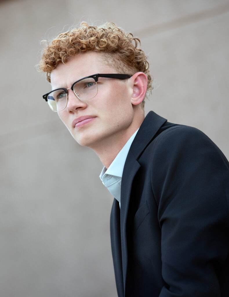 High school senior summer session close up looking in the distance wearing a blazer