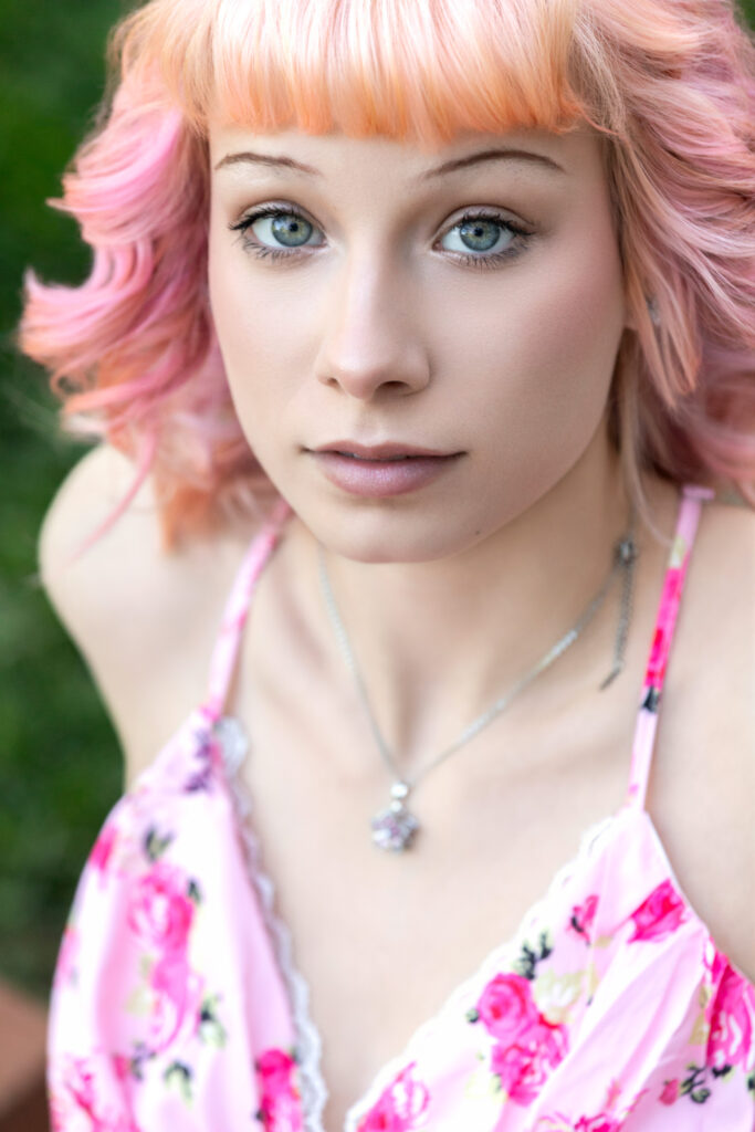 High school senior serious expression close up pink hair light eyes